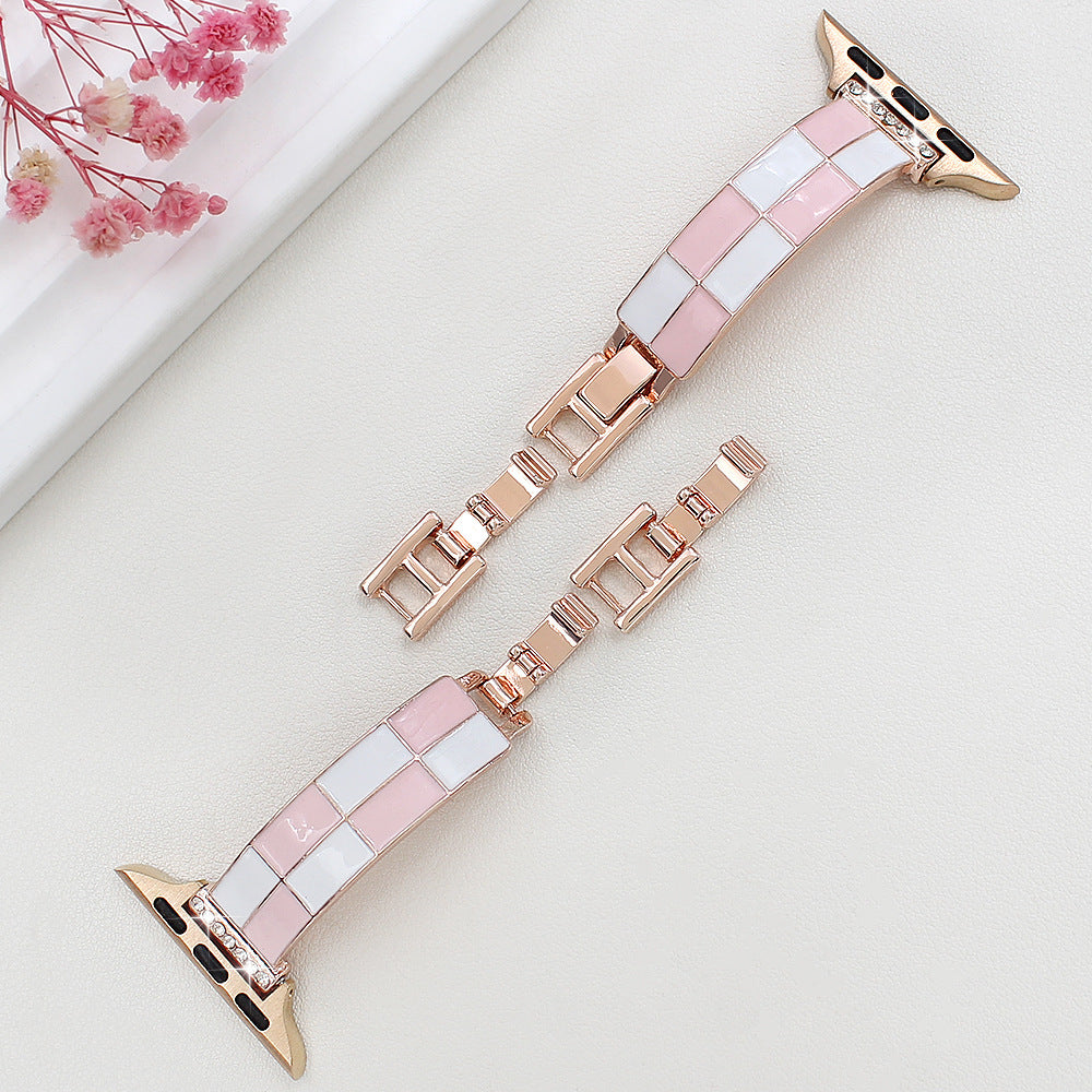 Pink and white checkerboard band with rose gold-tone metal, flat lay