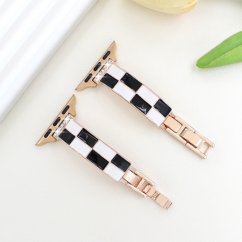 Black and white checkerboard band with rose gold-tone metal, flat lay