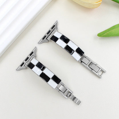 Black and white checkerboard band with silver-tone metal, flat lay